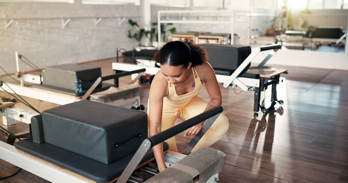 Safety, inspection and woman with reformer, gym and adjust springs for workout resistance or fitness. Health club, pilates instructor and person with equipment, maintenance and setup for exercise