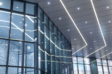 Modern building interior with glass walls and linear LED ceiling lights