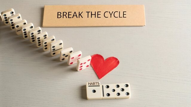 Dominoes falling representing breaking a cycle of bad habits