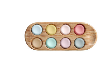 Pastel circles arranged in wood tray, black backdrop