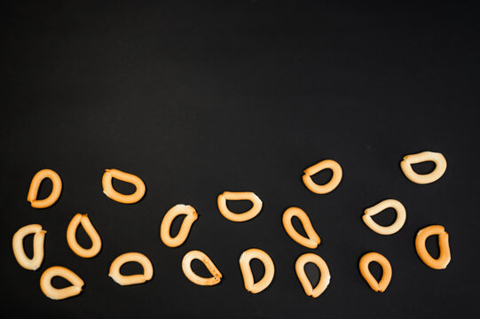 Small dry bread bagels on black background