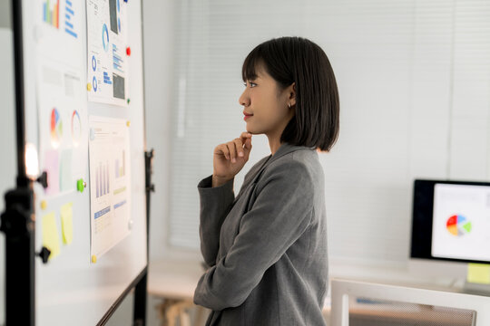 Asian businesswoman analyzing data and planning strategy in office