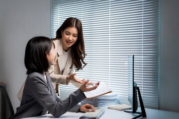 Businesswomen colleagues discussing work and collaborating in office