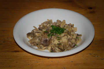 Dish with sautéed mushrooms garnished with chopped fresh parsley