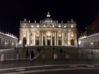 Illuminated St. Peter’s Basilica at Night in Vatican City with Tourists