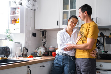 Husband and wife are romantically chatting in the kitchen in the morning