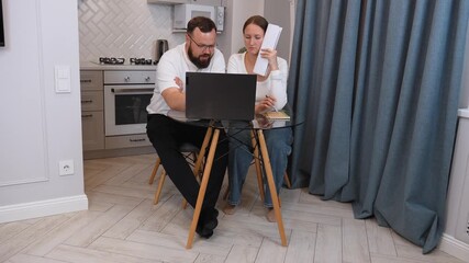 Young couple sitting at a glass table in their living room, discussing and managing their finances with a laptop and notebook, showing different moments of their conversation - Powered by Adobe