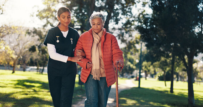 Outdoor, caregiver and senior woman with walking stick, health and help for rehabilitation or trust. Physical therapy, nurse and support for elderly patient with arthritis, care and people in nature