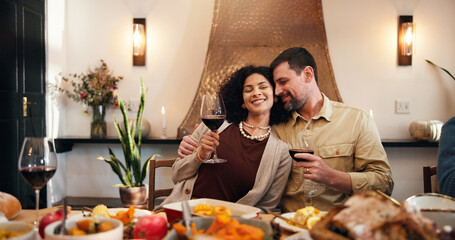 Thanksgiving, wine and hug with couple in dining room for holiday season, dinner or tradition. Festive feast, party and drink with man and woman in family home for food, hosting and hospitality