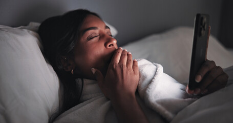 Yawn, night or woman in bed with phone, online reading or fatigue in social media browse. Dark, technology and female person in house with insomnia, tired or digital app scroll in late evening.