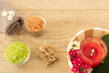 Towel with body care products on the wooden background.