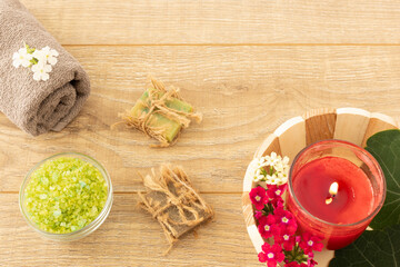 Towel with body care products on the wooden background.