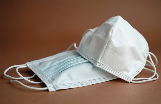 Two face masks. One white KN95 mask, one blue surgical mask for protection against virus. Safety measures for healthcare. Protection against spread of infection. Pandemic, airborne diseases