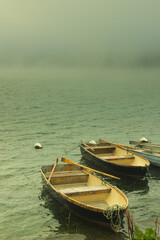 Obraz premium Wooden boats in the morning fog of Lake Sils, Engadine valley, Canton Graubünden, Switzerland