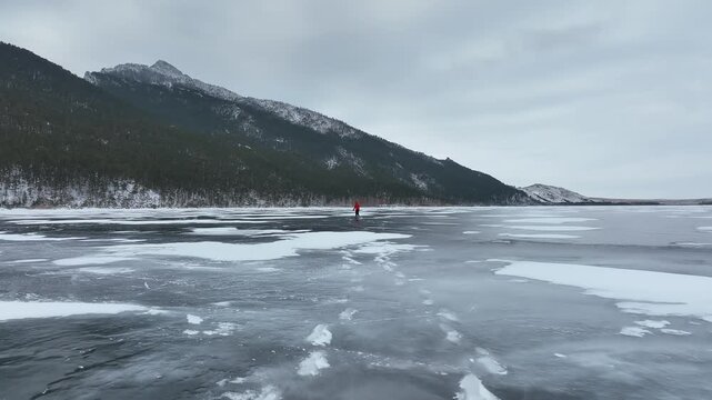 Aerial shot of a person skating on a vast Burabay frozen lake, Kazakhstan