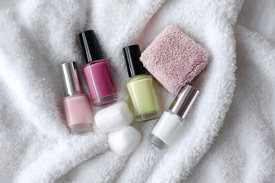 Vibrant nail polish collection and fluffy towel create a luxurious spa at home experience, perfect for beauty and self care visuals.