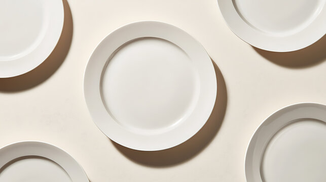 A minimalist composition of round, white ceramic plates arranged in a clean, geometric pattern on a cream surface, emphasizing light, shadow, and simple elegance.