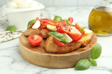 Tasty bruschettas with mozzarella cheese, tomatoes and basil on white marble table, closeup