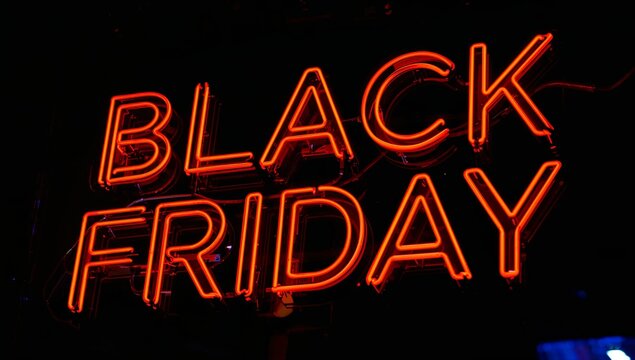 Bold neon 'BLACK FRIDAY' sign glows vibrantly red against a dark night, capturing the electric excitement of major sales events.