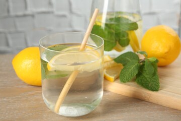 Refreshing water with lemons and mint on wooden table, closeup