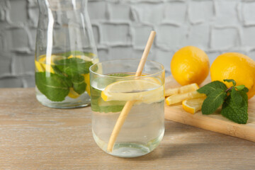 Refreshing water with lemons and mint on wooden table, closeup