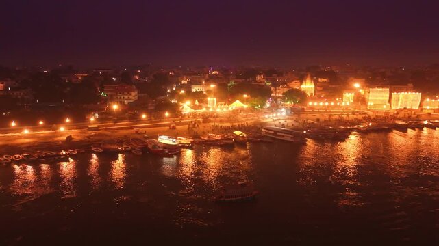 Drone shot of Assi Ghat and Ganga River in Varanasi. Boats on the water, glowing lights, and spiritual beauty define this sacred nightscape.