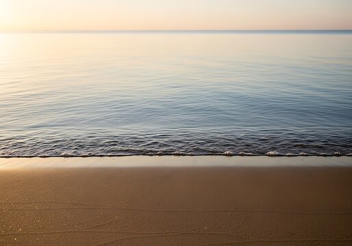 Serene shoreline vista featuring calming waves and a soft, sandy beach under a pastel sky
