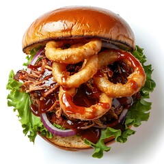 Overhead view of a burger with onion rings, lettuce, and sauce on a white surface