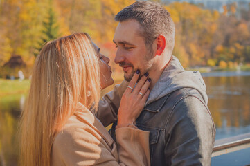 Fototapeta premium Elegant European couple walking together through picturesque city streets. Warm autumn light, gentle smiles, and cinematic vintage atmosphere 