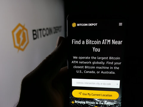 Stuttgart, Germany - 11-02-2025: Person holding cellphone with webpage of US BTC ATM (BTM) company Bitcoin Depot Inc. on screen in front of logo. Focus on center of phone display.