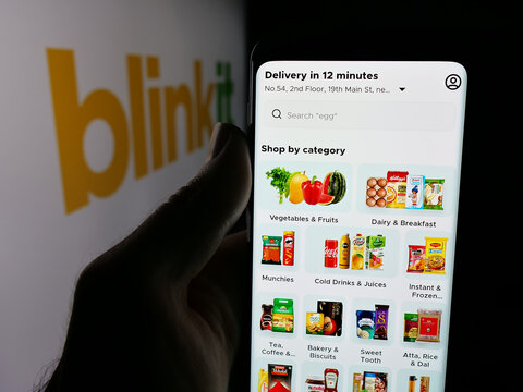 Stuttgart, Germany - 11-02-2025: Person holding smartphone with web page of Indian company Blinkit (Blink Commerce) on screen in front of logo. Focus on center of phone display.