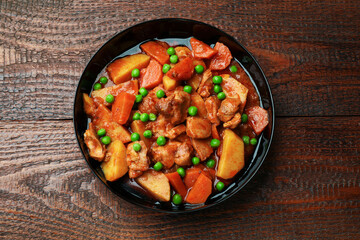 Delicious cooked stew on wooden table, top view