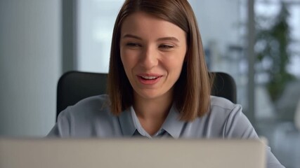 Smiling woman using laptop in office environment Stock Video - Powered by Adobe