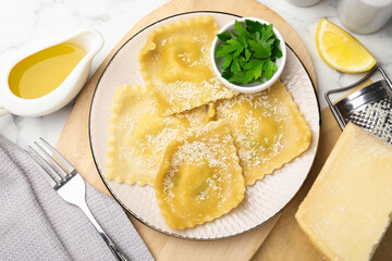 Delicious ravioli with cheese served on white marble table, flat lay