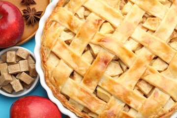 Tasty homemade apple pie and ingredients on light blue background, flat lay