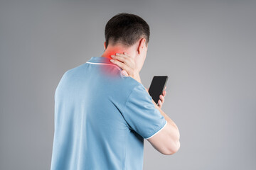 Man with neck pain from using smartphone, text neck and bad posture concept