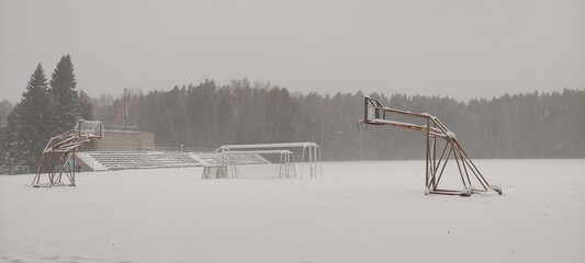 An outdoor sports ground is covered in snow after a blizzard.