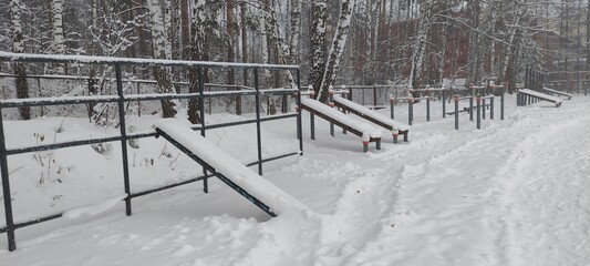 An outdoor sports ground is covered in snow after a blizzard.