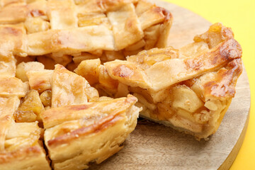 Delicious homemade apple pie on yellow background, closeup