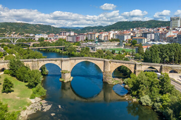 Fototapeta premium Aerial View of Ourense Cityscape with Modern and Roman Bridges