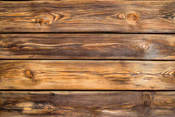 Obraz premium Close-up view of a rustic wooden surface, highlighting the unique textures and rich tones of the wood grain in natural light