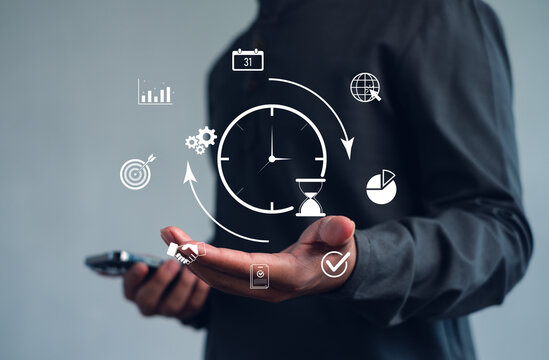 Businessman holding smartphone with virtual time management icons. Concept of productivity, project planning, digital workflow, and business efficiency for corporate success.
