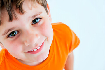 Portrait of Caucasian child boy smiling and looking into camera, showing missing tooth, standing against plain background, close up of face and upper body, cheerful expression