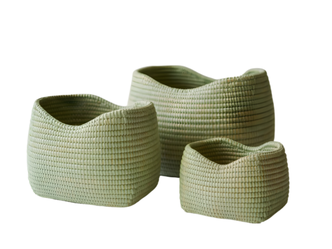 Three nested handwoven storage baskets made from natural fibers with a pale sage green color isolated on a transparent background.