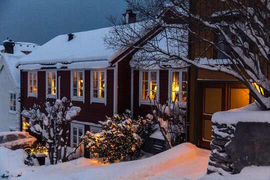 Cozy Scandinavian House Exterior in Winter Covered with Snow at Dusk - Powered by Adobe