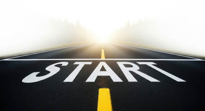 The word start painted on an asphalt road, with a bright sunburst at the end of the road, symbolizing new beginnings and opportunities