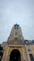 Extreme low-angle vertical shot of bell tower above stone entrance.