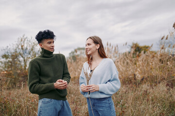 Two friends converse in a field, wearing cozy sweaters, conveying authenticity and credibility...