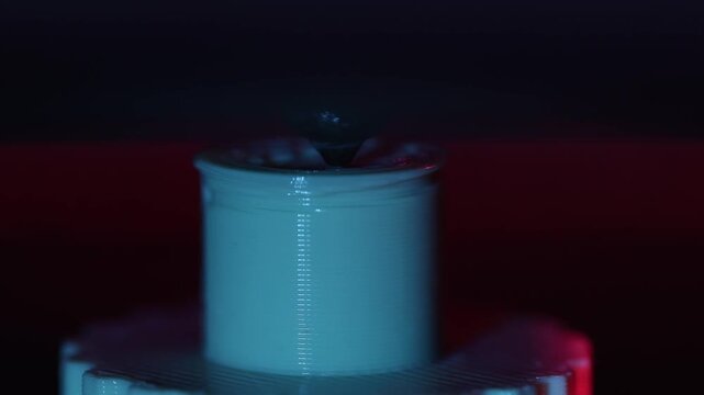 close-up of the 3D printer in action, showing the intricate details of the printhead and mounting plate, with gradual zooming in to show the manufacturing process and technology.