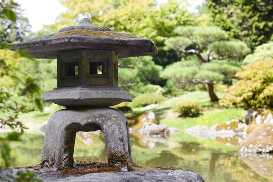 Stone lantern overlooking a reflective pond in the Seattle Japanese Garden, symbolizing harmony, culture, and peaceful natural balance.